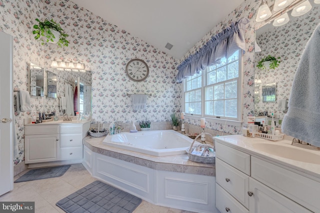 full bath featuring vaulted ceiling, wallpapered walls, two vanities, and a sink