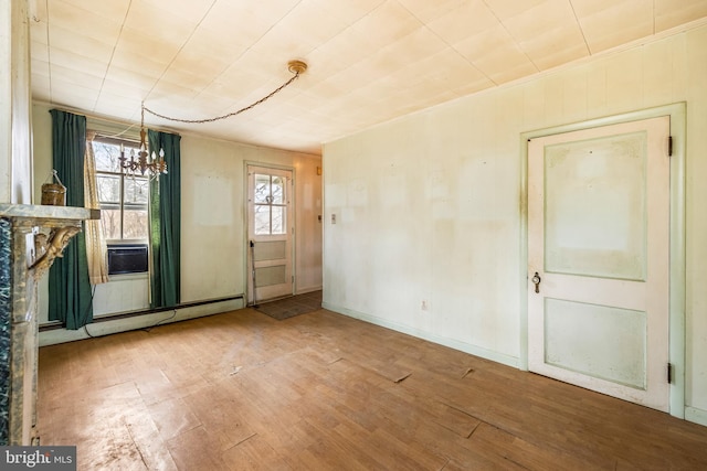 unfurnished dining area with a notable chandelier, baseboards, and wood finished floors