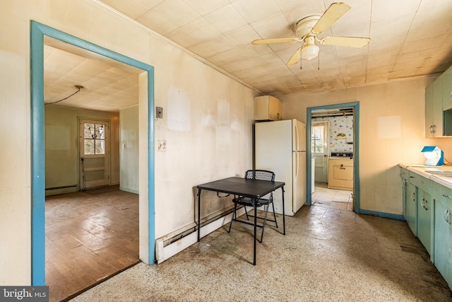 kitchen featuring a baseboard heating unit, washer / clothes dryer, ceiling fan, and freestanding refrigerator