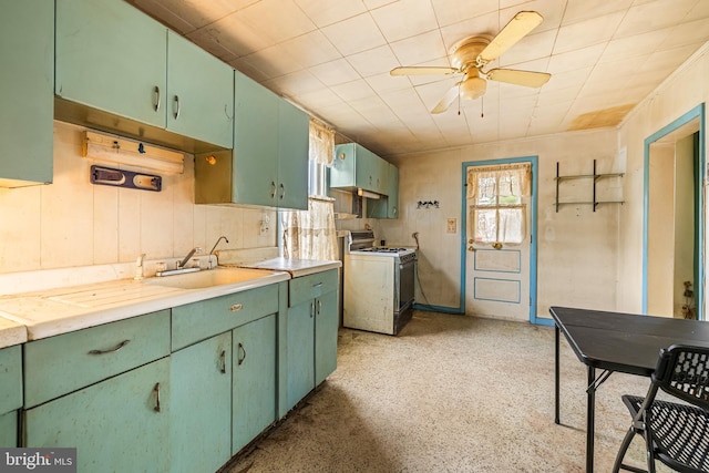 kitchen with ceiling fan, white range with gas stovetop, green cabinets, and light countertops