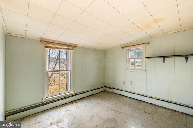 spare room featuring tile patterned floors and a baseboard heating unit