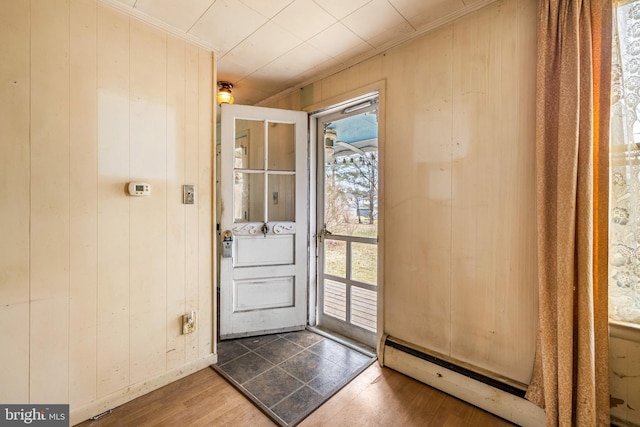 interior space featuring a healthy amount of sunlight, wood finished floors, ornamental molding, and wood walls