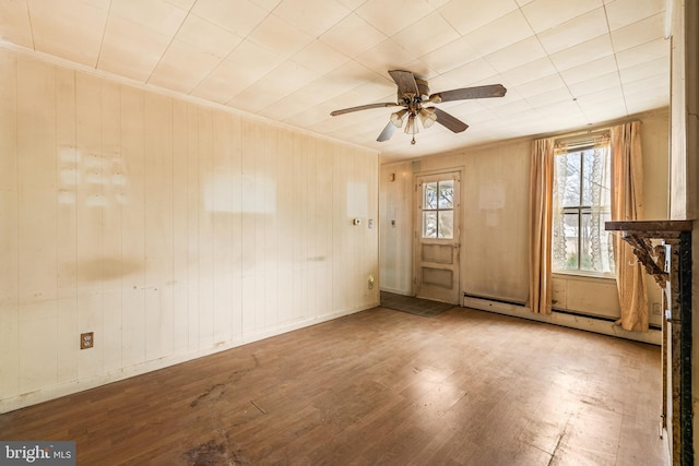 empty room with a baseboard radiator, wood finished floors, a ceiling fan, and ornamental molding