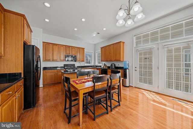 dining room featuring a notable chandelier, visible vents, light wood-type flooring, and recessed lighting
