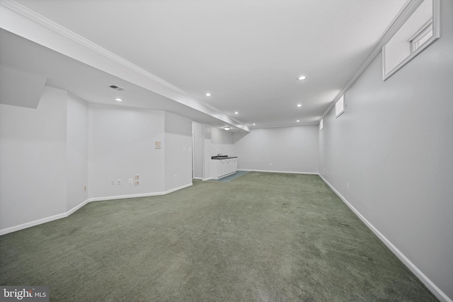 finished below grade area with recessed lighting, baseboards, light colored carpet, and ornamental molding