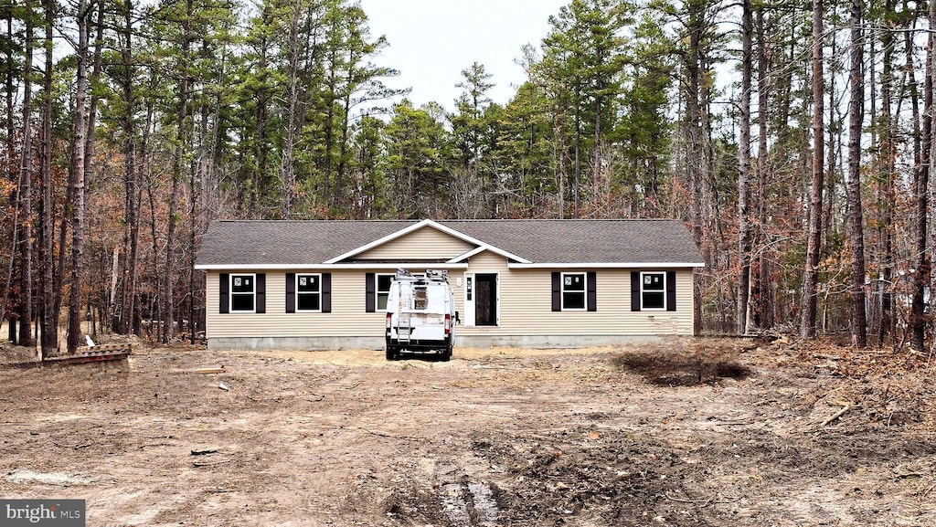 view of front of property with a wooded view