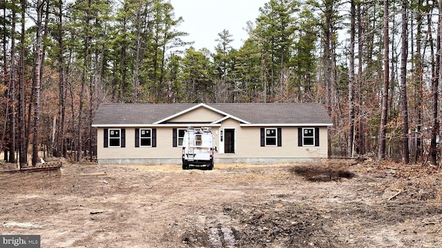 view of front of property with a wooded view