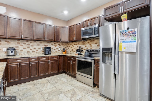 kitchen with dark brown cabinetry, tasteful backsplash, and stainless steel appliances