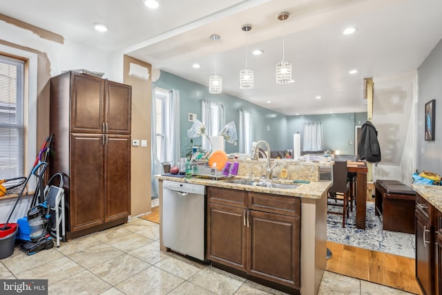 kitchen with decorative light fixtures, dishwasher, light stone counters, recessed lighting, and a sink