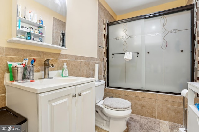 full bathroom with toilet, tile walls, and vanity