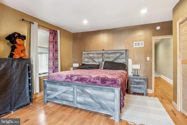 bedroom with recessed lighting, visible vents, baseboards, and wood finished floors