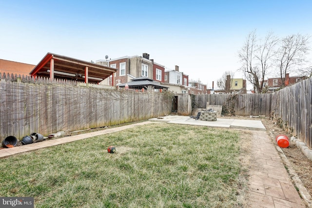 view of yard featuring a patio, a fire pit, and a fenced backyard