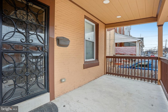 property entrance featuring a balcony and brick siding