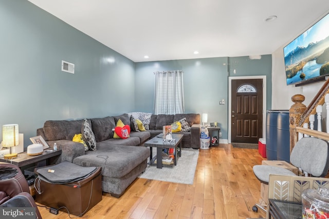 living room featuring light wood-type flooring, visible vents, and recessed lighting