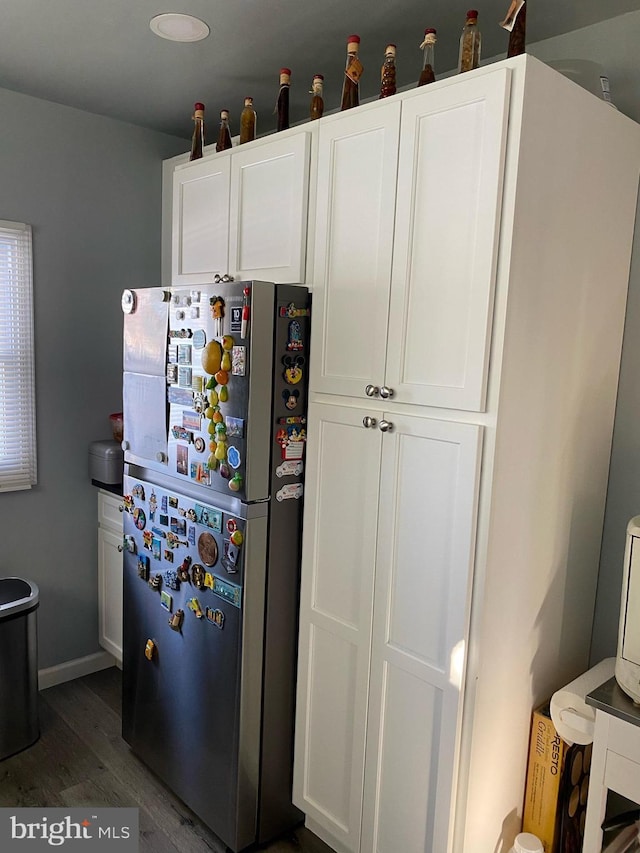 kitchen with baseboards, dark wood-style floors, white cabinets, and freestanding refrigerator