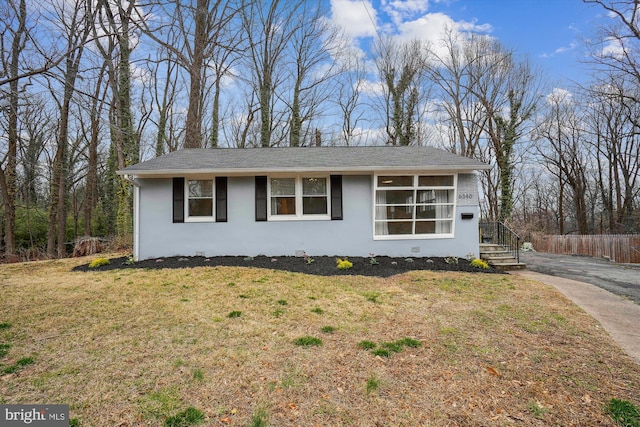 view of front of home featuring stucco siding, a front yard, and fence