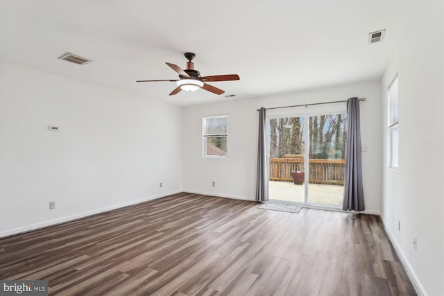 empty room with visible vents, baseboards, ceiling fan, and wood finished floors