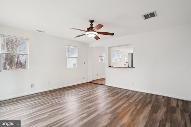 unfurnished living room with visible vents, baseboards, ceiling fan, and wood finished floors