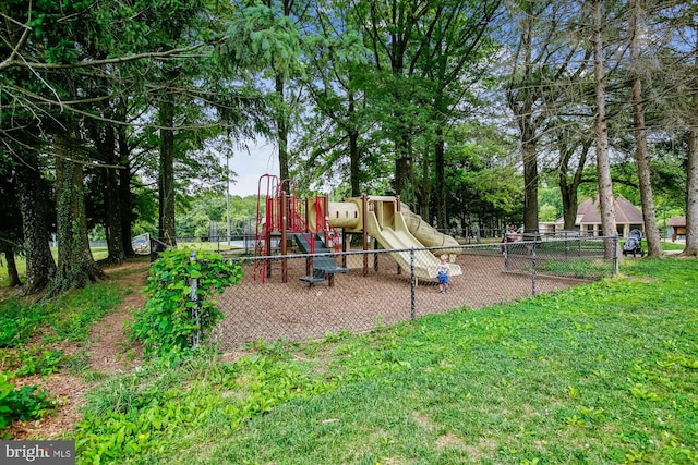 communal playground featuring a yard and fence