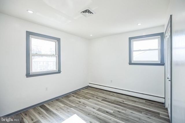 empty room with visible vents, baseboards, recessed lighting, light wood-style flooring, and a baseboard radiator