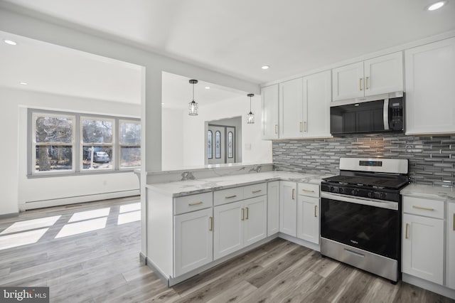 kitchen featuring tasteful backsplash, appliances with stainless steel finishes, white cabinets, light wood finished floors, and a baseboard radiator