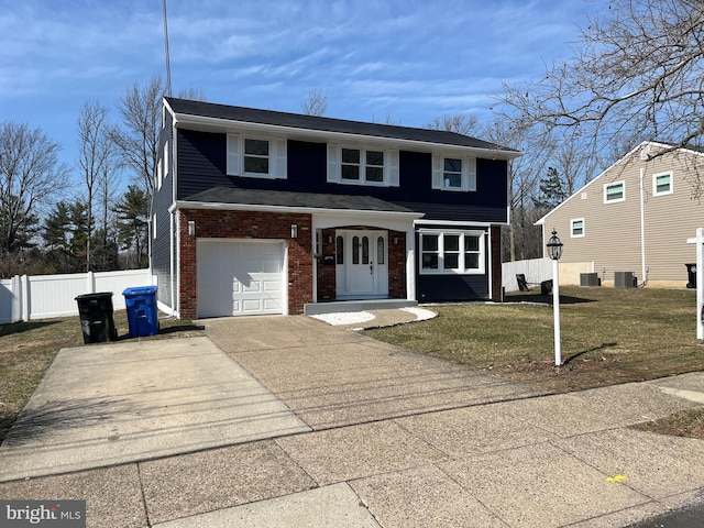 traditional-style home with brick siding, a front lawn, fence, concrete driveway, and an attached garage