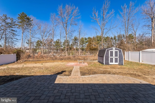 view of patio featuring a storage unit, an outdoor structure, and a fenced backyard