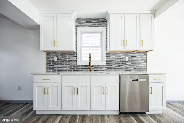 kitchen featuring backsplash, dishwasher, white cabinetry, and a sink