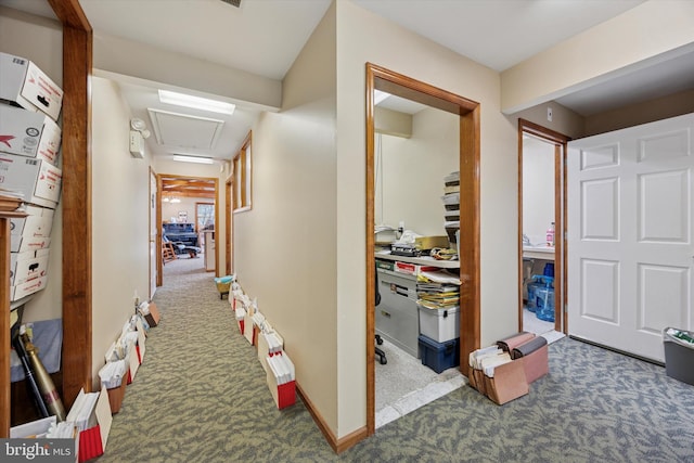 corridor featuring baseboards, attic access, and carpet