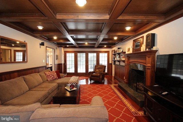 living room featuring beam ceiling, dark wood-style floors, wainscoting, and a premium fireplace