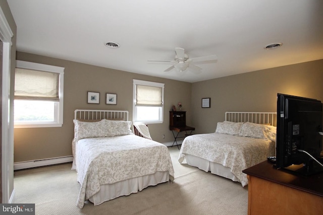 carpeted bedroom featuring multiple windows, visible vents, and baseboard heating