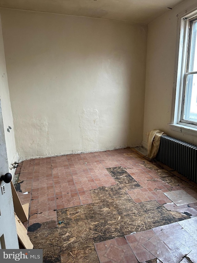 unfurnished room featuring radiator