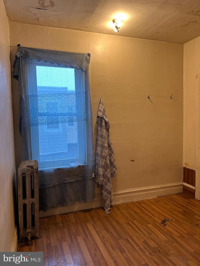 interior space with radiator and wood finished floors