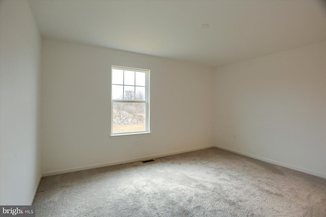 spare room featuring visible vents, baseboards, and carpet