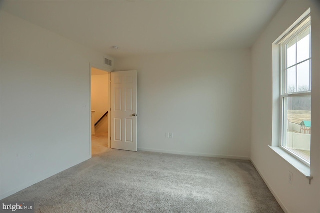 spare room with visible vents, baseboards, and carpet floors