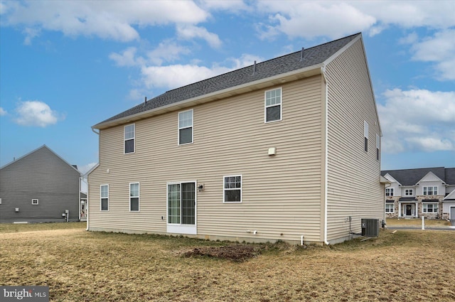 rear view of property with a yard and central AC