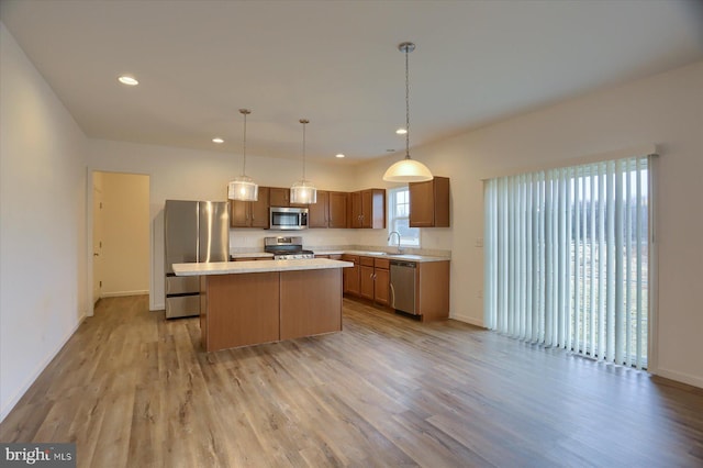 kitchen featuring a kitchen island, stainless steel appliances, light countertops, and light wood-style floors