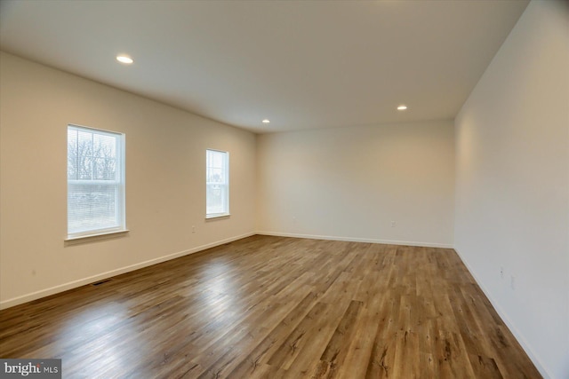 empty room featuring recessed lighting, baseboards, and wood finished floors