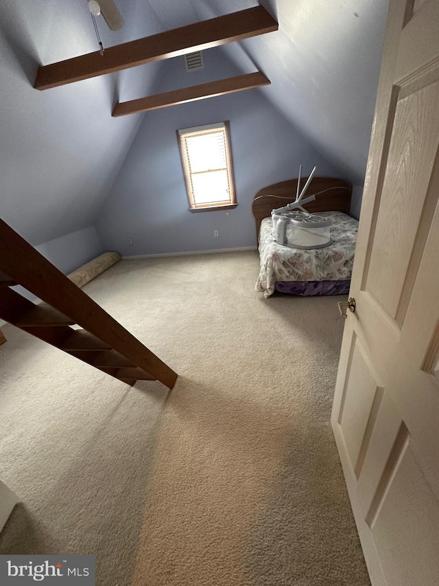 unfurnished bedroom with lofted ceiling with beams, visible vents, and carpet floors