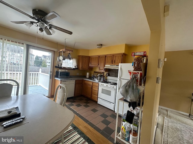 kitchen with ceiling fan, under cabinet range hood, brown cabinets, white appliances, and a sink