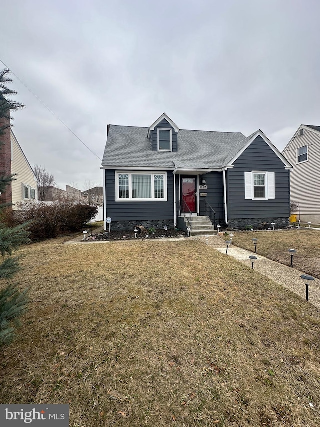 view of front facade with a front lawn and roof with shingles