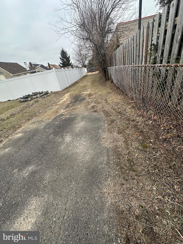 view of yard with driveway and fence