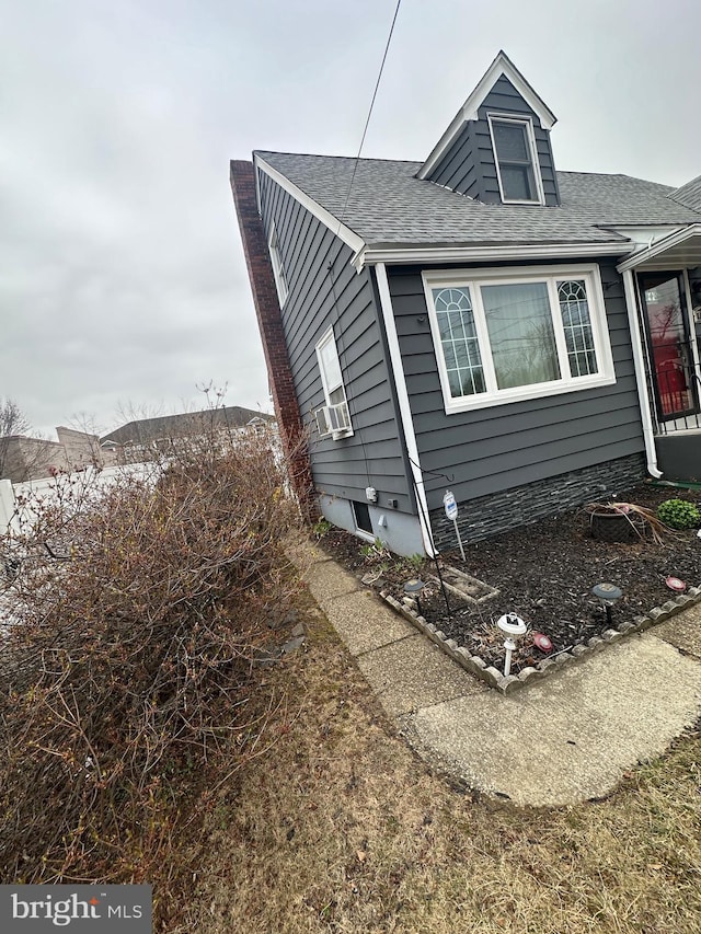 view of home's exterior with a shingled roof