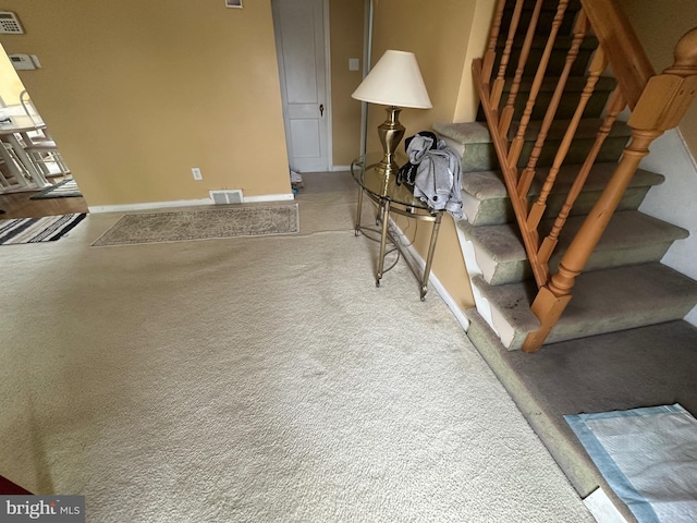 stairs featuring baseboards, visible vents, and carpet floors