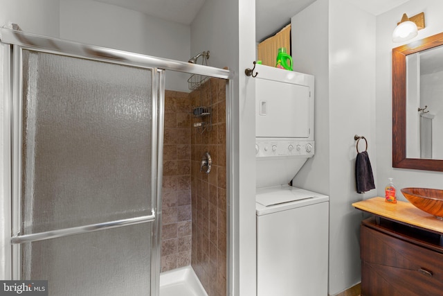 bathroom featuring a stall shower, stacked washer / drying machine, and vanity
