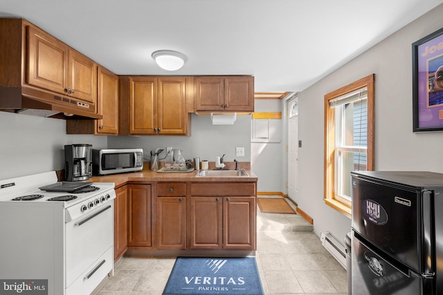 kitchen with a sink, freestanding refrigerator, white electric range oven, under cabinet range hood, and stainless steel microwave