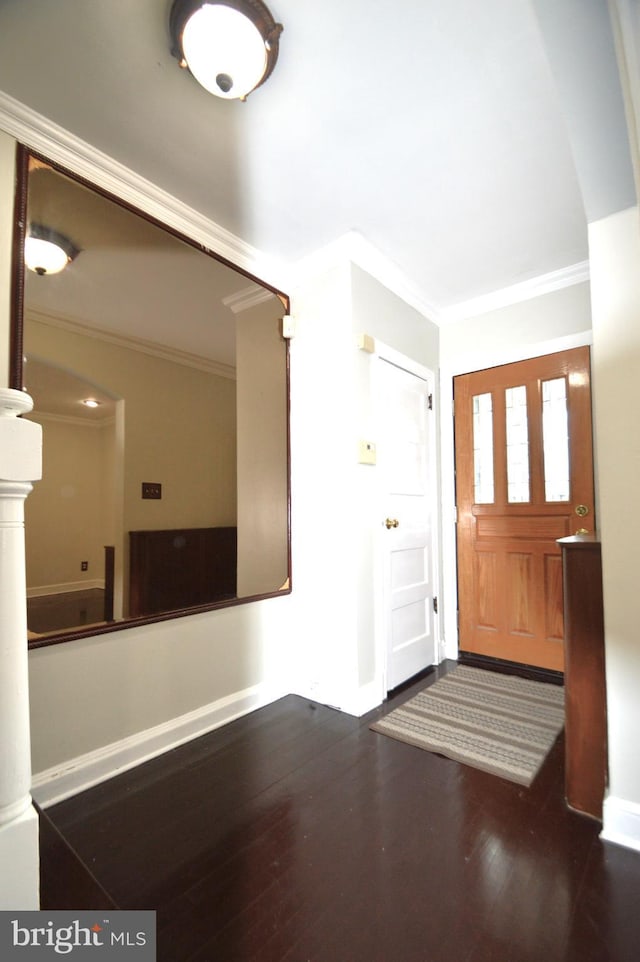 entryway featuring crown molding, wood finished floors, and baseboards