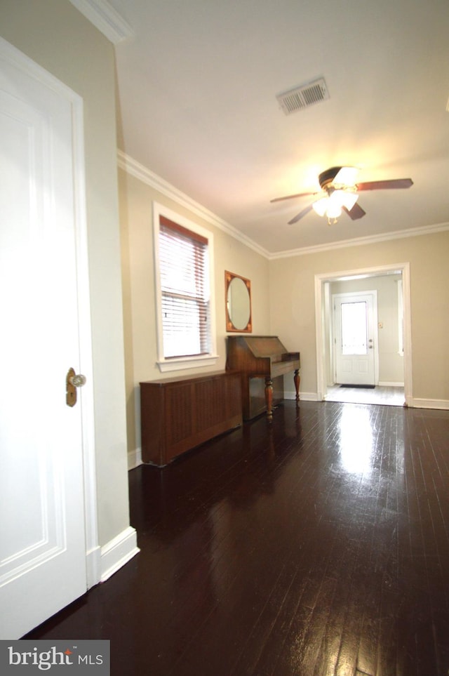 entryway with visible vents, hardwood / wood-style flooring, crown molding, baseboards, and ceiling fan