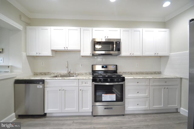 kitchen with backsplash, ornamental molding, appliances with stainless steel finishes, and a sink