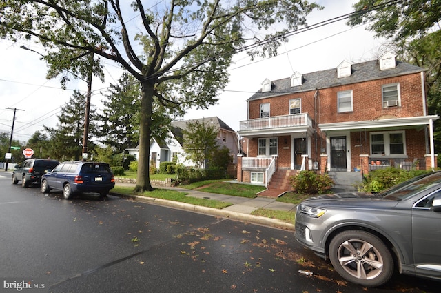 view of property with a porch and brick siding